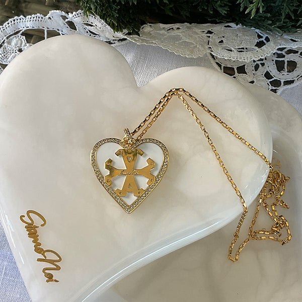 Dije de corazon, color blanco con borde de zircones y simbolo Siamo Noi en 18k Gold Filled, medida 3 x 3.5cm. Disponible en set con Zarcillos.