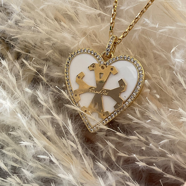 Dije de corazon, color blanco con borde de zircones y simbolo Siamo Noi en 18k Gold Filled, medida 3 x 3.5cm. Disponible en set con Zarcillos.