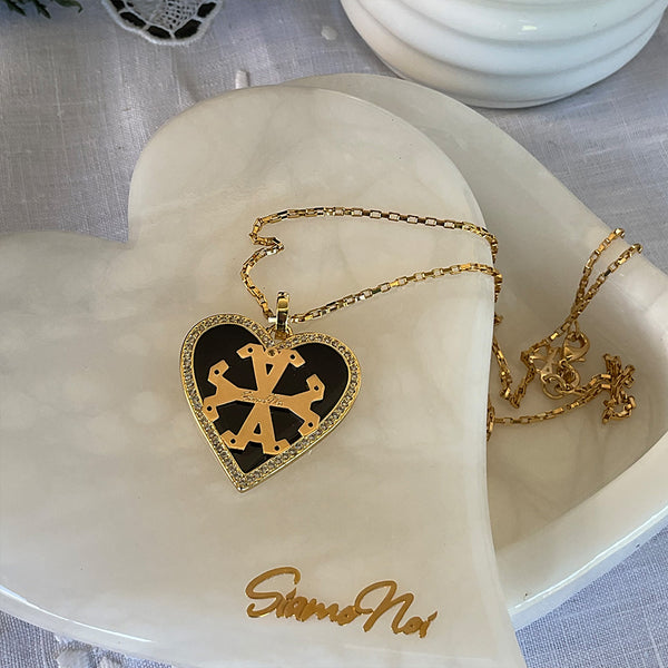 Dije de corazon, color blanco con borde de zircones y simbolo Siamo Noi en 18k Gold Filled, medida 3 x 3.5cm. Disponible en set con Zarcillos.