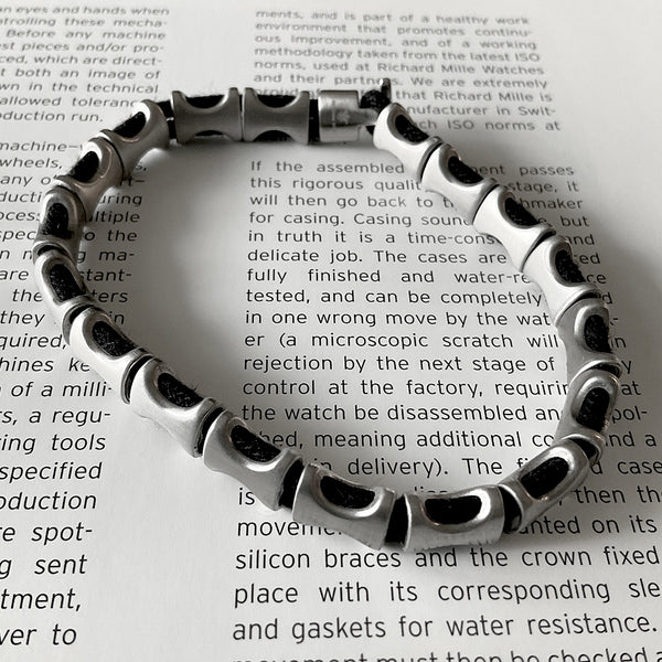Pulsera de hilo grueso negro con huesos de acero